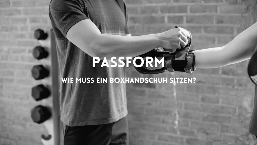 Mann zieht Boxhandschuh einer Frau an